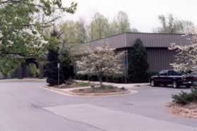 At the bottom of the hill cross the parking lot diagonally to the sidewalk along the Sports and Health Club building.