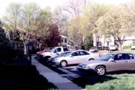 After passing the house on the left turn left to follow the sidewalk in front of the houses.