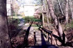 After crossing the bridge continue straight up the hill between the homes.