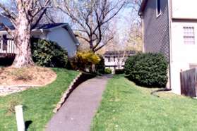 After reaching the other side of the pond turn right to follow the path between the homes.