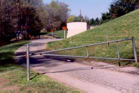 At the top of the hill turn sharply to the left to pass the barrier across the drive with the school on the right.