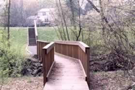 The boardwalk leads to steps that end at a pond. Turn right and follow the trail next to the pond.