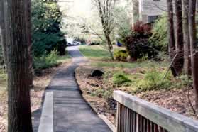 The path goes between the houses and leads to a road. Continue a short distance straight along the road.