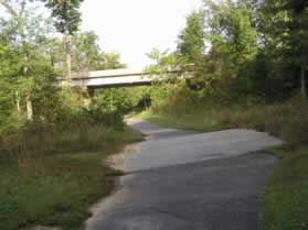 The trail passes over the old Lee Chapel Road alignment and then under the realigned Lee Chapel Road.