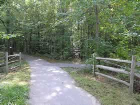 An asphalt trail from Lake Mercer intersects from the right.  Continue straight on the present trail.