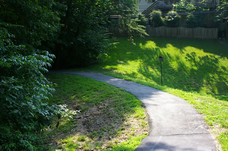 The trail goes behind the homes on the right.