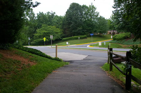The trail intersects with Hunter Village Dr. Stay to the left along the paved shoulder of that road.