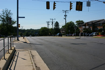 The trail passes Kingsbridge Dr. There is a service road to the left of the sidewalk.