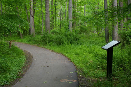 The hard surface trail passes a display on the right.