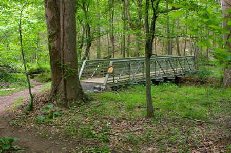 The trail goes down a short hill and passes over a bridge.