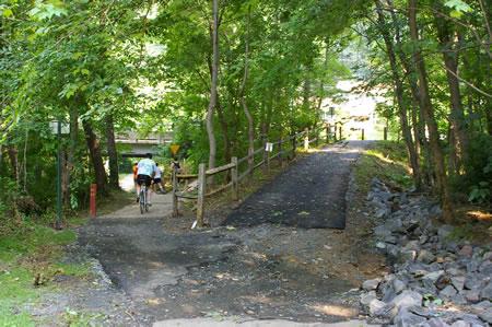 A trail intersects from the right connecting to King Arthur Rd. Stay on the trail to the left to pass under that road.