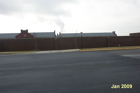 The trail crosses White Spruce Way prior to the entrance to the gated communityand turns right to follow the former Lorton Prison wall.