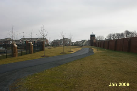 The trail follows the wall for a short distance and turns left to cross White Spruce Way .