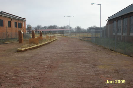 Walk across the brick surface and turn left at the end of the building on the left.