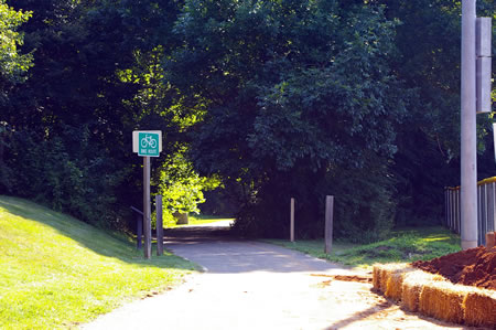 Take the asphalt trail at the north end of the parking lot heading east through the trees.