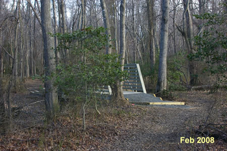 The trail crosses a creek on a bridge. The bridge is shown under construction in Feb. 2008.