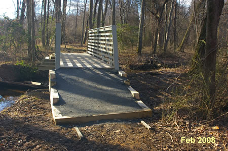 The trail crosses another creek on a bridge. The bridge is shown under construction in Feb 2008.