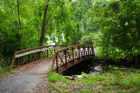 The trail crosses a bridge over a creek.