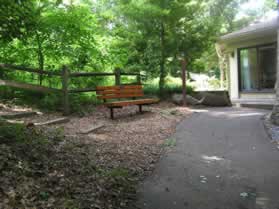 A trail intersects from the left.  Continue straight on the present paved trail.