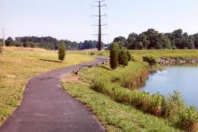 The buildings end on the left of the trail.