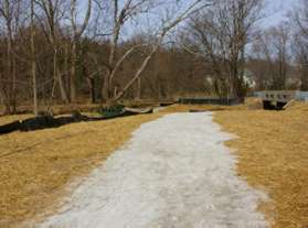 The asphalt surface ends and a stone dust surface begins.