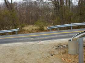 The trail turns right and crosses Browns Mill Road through the openings in the guardrails.