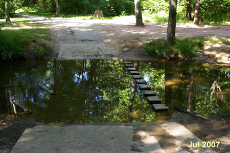 The trail to the left crosses on stones. Do not make this crossing.