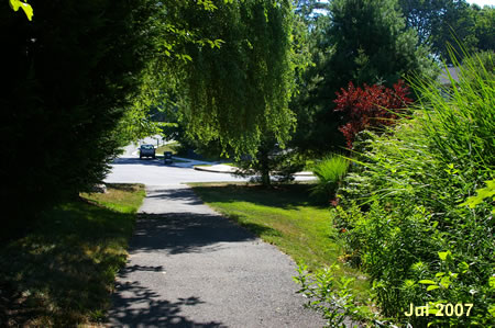 The trail passes between the houses and intersects with Foxstone Dr.
