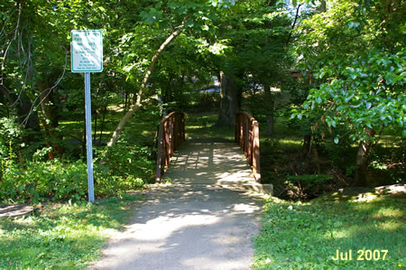 Follow the asphalt path at the end of the gravel access road and cross the creek.