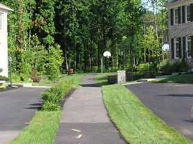 Follow the asphalt trail between the driveways back to a basketball court.