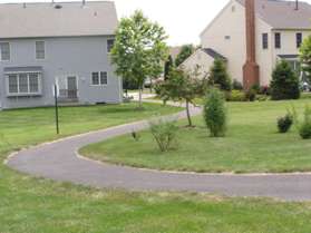 Follow the trail between the houses.