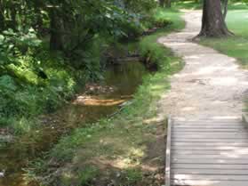 Just beyond the river trail a trail intersects from the right.  A stream flows along that trail and fills the canal with water for a short distance.  Continue straight on the present trail.