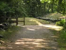 The trail to the left connects to the river trail. Continue on the present trail as it turns right to cross a bridge.