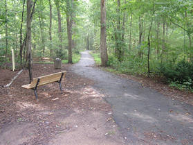 Start on the asphalt path heading east from the pool parking lot. Notice the bench next to the path.