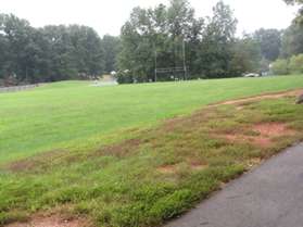 The trail passes by a soccer field on the left.