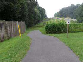 The trail passes a garden plot on the right.