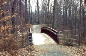 The trail crosses a bridge over a gully.