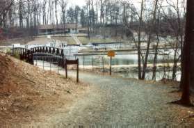 The trail leaves the woods and crosses a bridge.