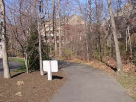 The trail cuts between the houses headed towards the lake.