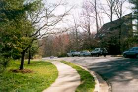 Take the sidewalk at the top of the hill.  Cross the street to the sidewalk on the Lake Anne side.