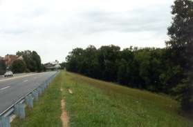 The dirt path follows South Lakes Dr across the Lake Thoreau dam.