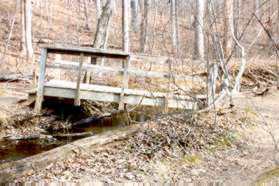 The trail to the right crosses a bridge over Colvin Run after a short distance.  Continue up the hill.