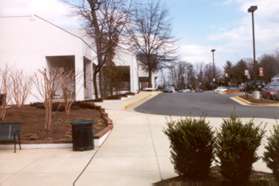 Continue straight following the sidewalk in front of the grocery store.