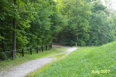 The dirt and gravel trail on the dam side of the barrier leads down to parking along Hooes Rd.  It connects to another trail that follows South Run downstream. If you started from the Hooes Rd. parking area turn right to go down this trail.