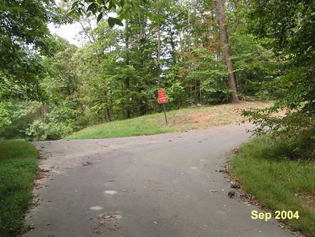 An asphalt trail splits off from the service road.  Go right to follow that path up the hill.