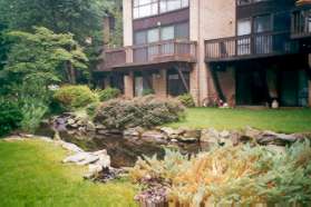 A small pond can be seen behind the homes.