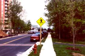 Turn right onto the wide asphalt trail adjacent to the pedestrian crossing sign.