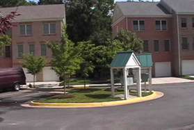 The path crosses a parking area at the end of Waterhaven Ct.  The path goes between the homes on the other side and down a flight of wooden steps.