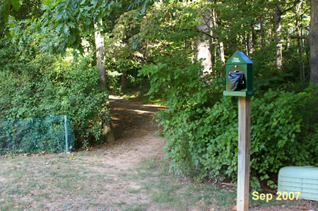 The trail enters the woods going west from the edge of the baseball field.