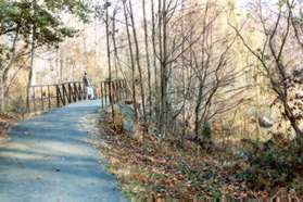 The trail crosses a bridge with Lake Audubon on the right.